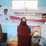 PSX_20220719_203552 Anggota DPR RI, Bahtra (kameja) saat menyerahkan bantuan beras kepada masyarakat Desa Mattirowalie, Kecamatan Poleang, Kabupaten Bombana, Senin (18/7/2022). Foto/ist